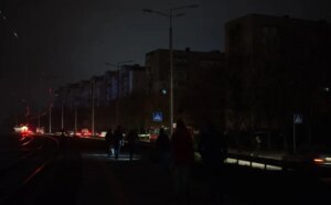 Мешканці Криму йдуть темною вулицею серед багатоповерхівок під час блекауту