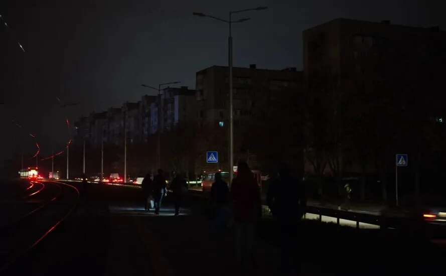 Мешканці Криму йдуть темною вулицею серед багатоповерхівок під час блекауту