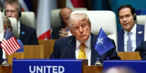 Дональд Трамп на саміті НАТО з прапором США та НАТО