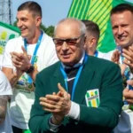 Геннадий Буткевич аплодирует среди игроков Полесья с медалями