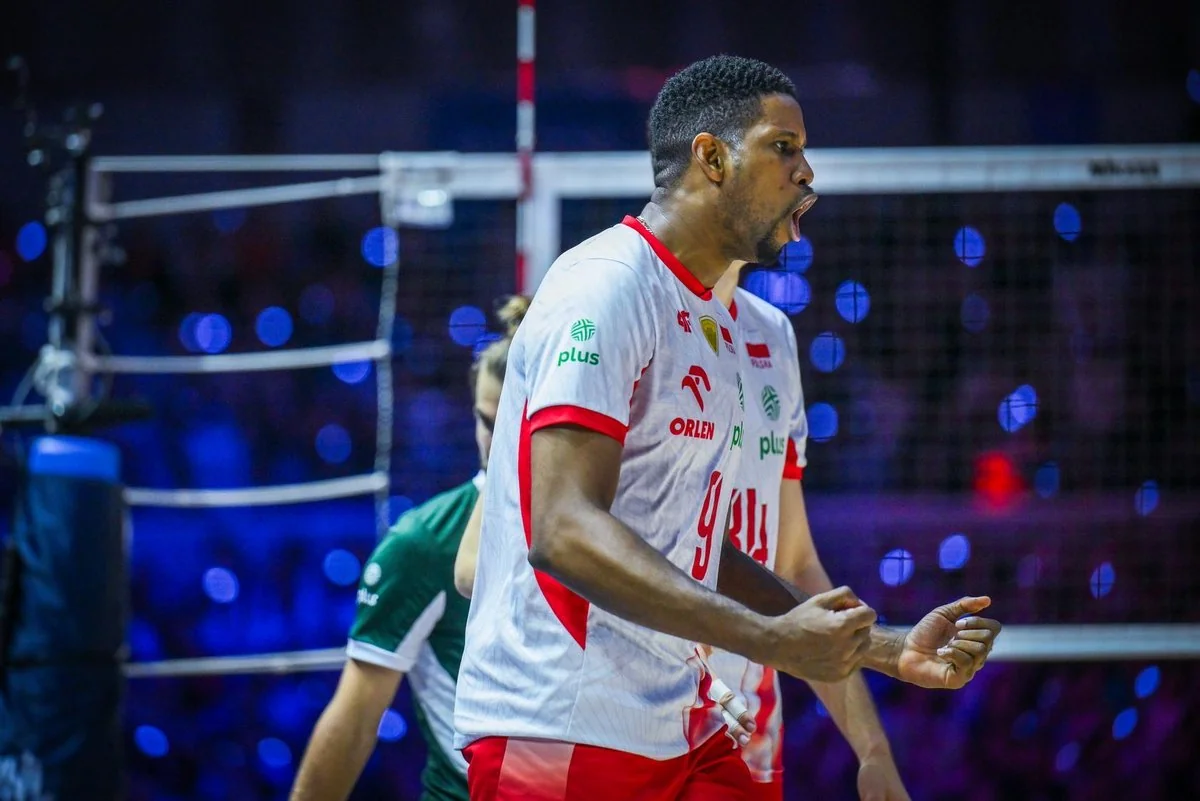 Волейболіст збірної Польщі в білій формі з номером 9 радісно кричить на майданчику